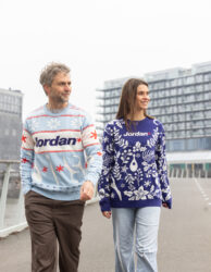 2 modellen lopend over straat in bedrukte kersttruien. 1tje in het licht en de andere in het donker blauw.